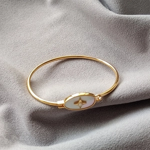 Détail du bracelet en laiton doré avec nacre blanche et motif d'étoile polaire