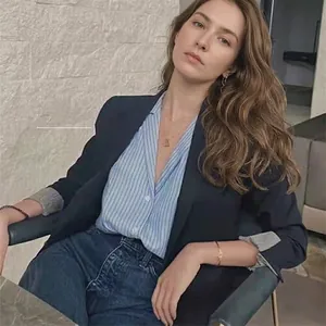 Elegant gold chain link earrings paired with a navy blazer and striped shirt for women