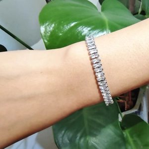 Détail d'un bracelet de tennis argenté avec cristaux rectangulaires porté au poignet