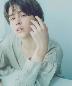 Minimalist gold faceted snake chain bracelet on a model wearing green satin shirt