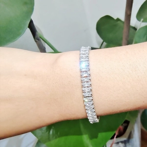 Détail d'un bracelet tennis étincelant avec zircons baguettes porté sur le poignet
