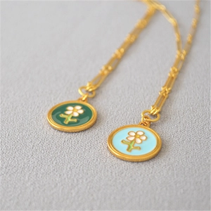Détail macro du collier plaqué or avec pendentif fleur en émail fait à la main
