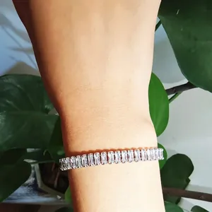 Gros plan d'un bracelet en argent scintillant serti de zircons porté au poignet