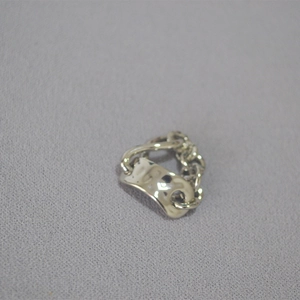 Close-up of industrial chain ring with a hammered texture irregular metal plate