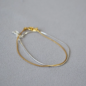 Detail of adjustable gold and silver snake chains with lobster clasp and extension links