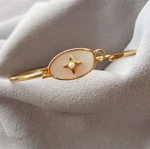 Détail d'un bracelet doré avec incrustation en nacre et ornement d'opale en étoile