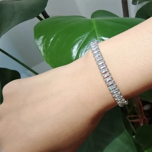 Vue détaillée du bracelet tennis argenté avec zircons taille baguette porté au poignet