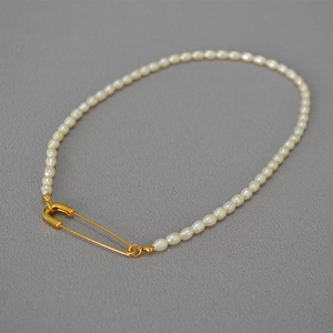 Detail of freshwater rice pearl necklace with a creative golden safety pin buckle design