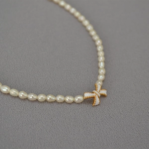 White enamel butterfly pendant with freshwater rice pearl necklace on grey background