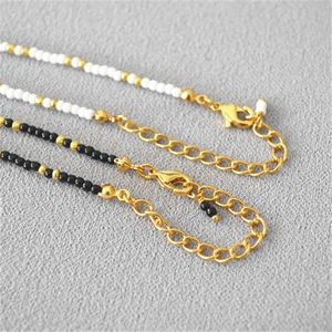 Close-up of gold-plated lobster clasp and extension chain on beaded necklace