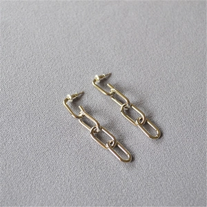 Minimalist silver chain link earrings with industrial design on gray textured fabric