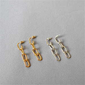 Close-up of long metal chain earrings in gold and silver finish with 925 silver needles