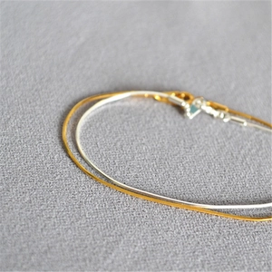 Minimalist gold and silver ultra-thin snake chain bracelets set in a stacked style