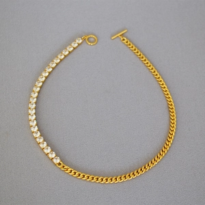 Detail of gold-plated necklace featuring mixed curb chain, zircon inlay and toggle clasp