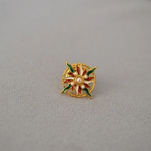 Détail macro d'une broche tournesol en émail avec perles et touches colorées