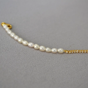 Détail de perles d'eau douce et chaîne en zircone avec fermoir mousqueton doré chic