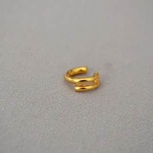 Detail view of double-layered spiral ear cuff in polished gold finish for non-pierced ears