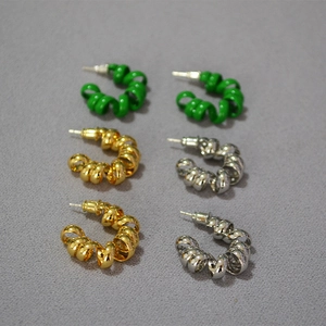 Détails de boucles d'oreilles spirales en finitions verte, dorée et argentée brillante