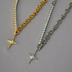 Detail of mixed-link chain necklaces in gold and silver with zircon star pendants
