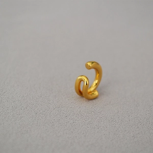 Close-up of minimalist double-layer golden ear cuff with a polished metallic finish