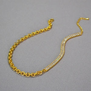 Detail of mixed-metal gold chain and baguette-cut cubic zirconia stones on necklace