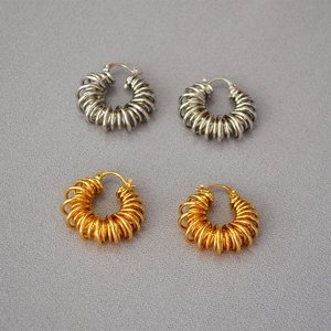 Close-up of gold and silver spiral spring earrings in vintage telephone wire design