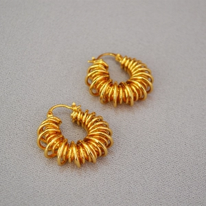 Macro shot of gold-plated twisted telephone line spiral earrings with polished finish