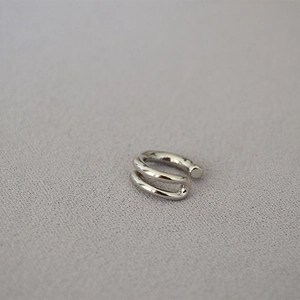 Macro view of minimalist silver double-layer ear cuff with polished metallic finish