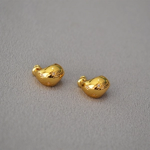Irregular golden bean earrings with starburst zircon inlay in a 45-degree angled view