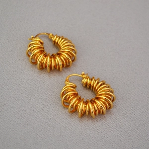 Detailed macro view of gold-plated twisted coil hoop earrings with spiral layered design
