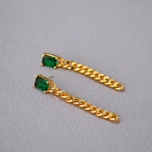 Detail of emerald green stone earrings with elegant gold chain tassels and 925 silver pins