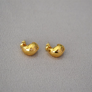 Macro shot of gold irregular crescent stud earrings featuring star engravings and zircons