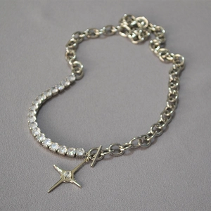 Detail of cross star pendant with toggle clasp on mixed curb and tennis chain necklace
