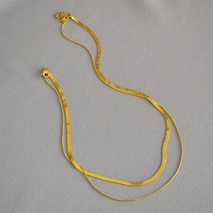 Detailed view of golden double-layer snake chain with lobster clasp and extension