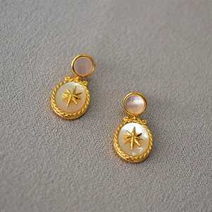 Macro view of vintage gold starburst earrings with iridescent mother of pearl inlays