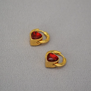 Détail de pendentifs cœur en verre rouge sur boucles d'oreilles créoles dorées en laiton