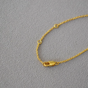 Detailed macro view of a gold-plated cable chain with a secure lobster clasp and rings