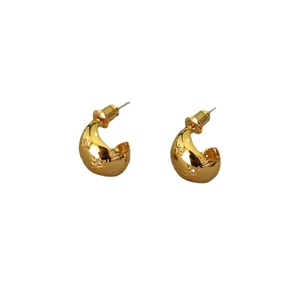 Golden C-shaped earrings with star engravings and cubic zirconia on white background