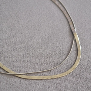 Close-up of double-layered gold snake chain necklace showing metallic texture and details