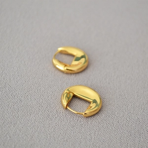 Vue macro de boucles d'oreilles en laiton doré poli avec finition miroir lisse
