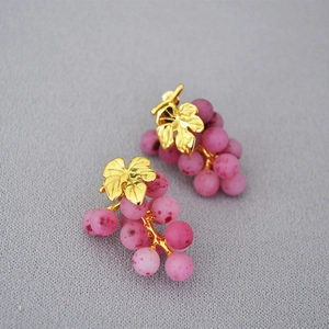 Detail of grape shape earrings with golden leaves and frosted pink purple beads