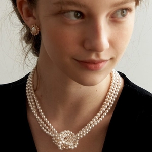 Elegant triple-strand pearl necklace with woven knot and matching stud earrings set