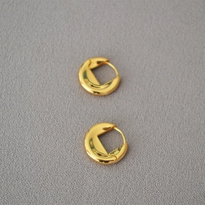 Boucles d'oreilles créoles dorées épaisses de style minimaliste français sur tissu gris