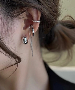Close-up of silver-plated ear cuff set with thick hoop and chain tassel for layered wear