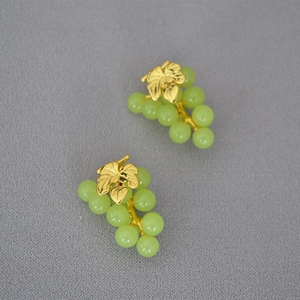 Macro detail of gold leaf earrings with green grape beads in 925 silver pin design