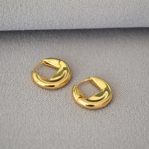 Vue macro des boucles d'oreilles disque plaquées or avec finition miroir polie