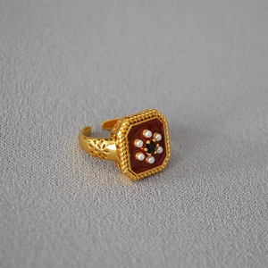 Detailed view of vintage square ring with red enamel, pearls and ornate hollow carvings