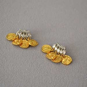 Dettaglio di orecchini vintage con monete d'oro, cristalli marquise e trame metalliche