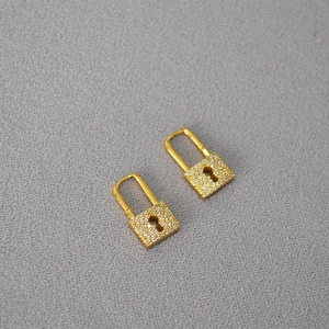 Macro shot of gold-plated brass lock earrings with micro-pave cubic zirconia crystals