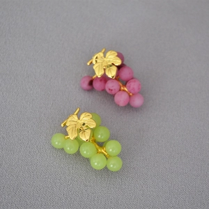 Detail of grape earrings with matte purple and green beads and golden leaf design
